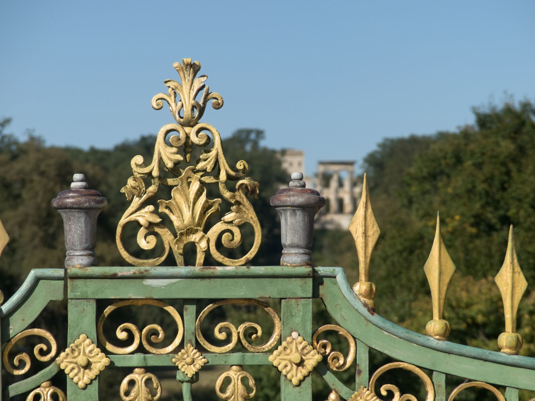 Close-up of an ornate green and gold gate at Park